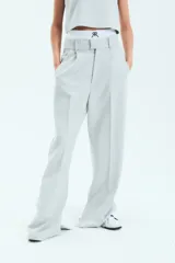 Pantalón de vestir estilo sastrero en color gris, confeccionado en crepe. Presenta un corte recto y holgado con tajo en la botamanga interna y bolsillos laterales.