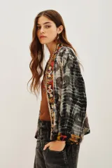 Kimono de viscosa con diseño estampado de círculos y efecto tie-dye, con bordes frontales decorados con aplicaciones bordadas y pedrería multicolor.