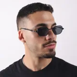 Lentes de sol con armazón metálico negro y cristales oscuros de forma hexagonal. Cuentan con protección UV400 y diseño moderno.