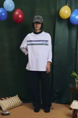 Remera de manga larga blanca con cuello alto en color azul. Presenta franjas horizontales de colores en el pecho y el logo de la marca estampado.
