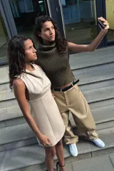 Top de tejido de punto acanalado color verde militar, con cuello alto tipo tortuga y mangas sisa. Presenta un bajo asimétrico con aberturas laterales.