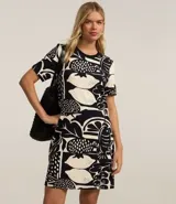Vestido corto de corte recto estilo camiseta, con cuello redondo y mangas cortas. Presenta un estampado gráfico en blanco y negro con motivos de frutas (limones, granadas) y peces.