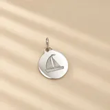 Medalla redonda de plata 925 con diseño grabado de un velero.