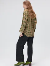 Camisa de seda con cuello camisero, manga larga y bolsillo frontal. Presenta un diseño estampado geométrico de cuadrados en tonos marrones y azul oscuro.