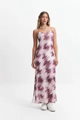 Vestido largo con estampado abstracto en tonos lila y blanco, breteles finos regulables, escote en V, espalda con tiras entrecruzadas y tajos laterales.