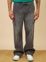 Pantalón cargo de jean con efecto lavado, corte recto y holgado. Cuenta con cintura elástica con cordón de ajuste y bolsillos laterales tipo cargo con solapa.