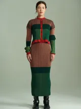 Falda midi de punto acanalado con diseño multicolor de rayas verticales en tonos rosado, rojo, celeste y blanco, con pretina elástica de tiro alto y corte tipo lápiz.
