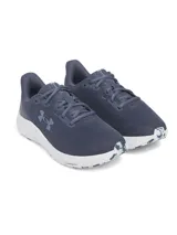 Championes de running Under Armour modelo Charged Pursuit 4, color gris con entresuela blanca. Presentan una parte superior de malla transpirable, logo de la marca en el lateral y tecnología Charged Cushioning en la entresuela para mayor amortiguación y respuesta.