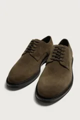 Zapato de cordones tipo derby para hombre, fabricado en piel con acabado en serraje de color azul marino, con horma redonda y suela a contraste.