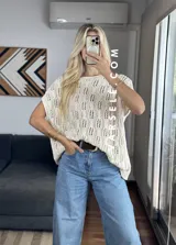 Remerón de crochet color crudo, con cuello redondo y mangas cortas.