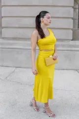 Vestido midi de un solo hombro, color mostaza, con diseño ajustado y falda fluida con abertura.
