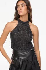Top de punto estilo halter, color crudo, con cuello alto ajustado, diseño sin mangas y corte corto.