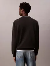 Buzo de algodón negro Calvin Klein, de cuello redondo, mangas largas y calce clásico. Presenta un pequeño parche con el monograma de la marca en el pecho y puños con ribete acanalado.