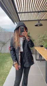 Campera negra con capucha, cierre frontal con cremallera y bolsillos laterales. Interior con forro de animal print.