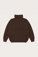 Polera de cuello alto en color marrón, con diseño de corte asimétrico en el ruedo y costuras decorativas frontales.
