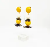 Aros colgantes con clip, con diseño de esferas de resina color amarillo, blanco y marrón, con detalle de flor en la parte inferior.