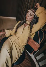 Camisa color amarillo, con cuello en V, mangas largas abullonadas con puños elásticos y lazo ajustable en la cintura.