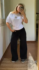 Pantalón de jogging color negro, de corte recto y holgado, con cintura elástica ajustable mediante cordón y bolsillos laterales.
