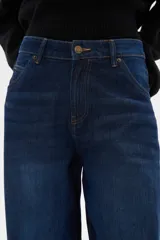 Pantalon jean de corte barrel y tiro medio, en color negro, con diseño de pierna ancha y estructura rígida.