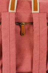 Mochila de lona estilo vintage con solapa frontal, bolsillos laterales y correas ajustables. Presenta detalles en cuero sintético y un parche decorativo en la parte superior.