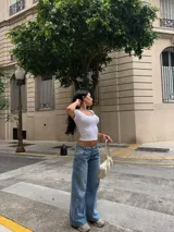Pantalón de jean estilo wide leg y tiro bajo, en tono azul claro con efecto deslavado y diseño de perneras amplias.