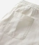 Bermuda recta de playa en color blanco roto, confeccionada en algodón texturizado con efecto de rayas verticales. Posee cintura elástica con cordón ajustable.