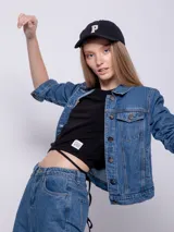 Campera de jean celeste con cuello clásico, cierre frontal con botones metálicos, mangas largas con puños abotonados, bolsillos delanteros con solapa y corte recto.