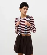 Blusa cropped Blue Steel de manga larga y cuello redondo, confeccionada en ribana con diseño a rayas horizontales en tonos bordó y rosado.