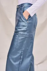 Pantalón cargo azul metalizado de corte wide leg y tiro medio, con bolsillos laterales y cierre frontal con botón y cremallera.