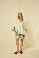 Minivestido blanco de lino con escote en V, mangas anchas acampanadas y bordados dorados en los puños, el dobladillo y el cinturón ajustable.