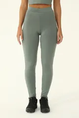 Calza deportiva de tiro alto color verde, con recortes anatómicos y cierres en los tobillos. Confeccionada en tejido de compresión con tecnología de absorción de sudor.