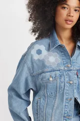 Campera de jean celeste con apliques de tela estampada con motivos geométricos.