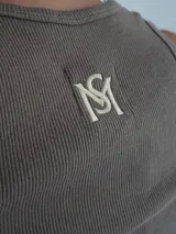 Musculosa negra de punto acanalado con corte ajustado y bordado de caballo en el pecho.