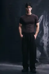 Pantalón de jogging deportivo de corte holgado, confeccionado en tejido técnico con tecnología de absorción de humedad. Presenta cintura elástica con cordón de ajuste, bolsillos laterales, ribetes verticales en las piernas y cordón elástico ajustable en los bajos.
