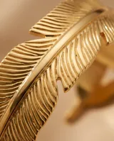 Pulsera tipo esclava rígida de acero con baño de oro, diseñada con una textura detallada que simula una pluma envolvente.