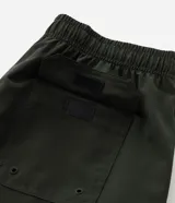 Bermuda Blue Steel de corte clásico, confeccionada en tejido ripstop de poliamida con elastano, en color verde militar. Cuenta con cintura elástica con cordón de ajuste interno, bolsillos laterales y un bolsillo con cierre en el lateral del muslo.
