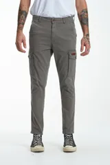 Pantalón cargo gris de gabardina, corte slim, con bolsillos laterales con solapa y bolsillos traseros con ojal y botón. Presenta efecto teñido en la tela.