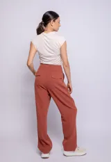 Pantalón de vestir color ladrillo, de corte recto y tiro alto, con bolsillos laterales y pinzas delanteras.