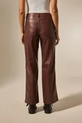Pantalón marrón de eco-cuero, corte ancho y tiro bajo, con bolsillos laterales.