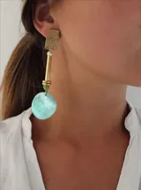 Aros colgantes con base dorada y dije circular de color celeste.