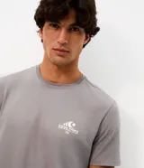 Remera gris de manga corta con cuello redondo, confeccionada en algodón peruano. Presenta un pequeño estampado en el pecho con diseño de ola y la inscripción 'Good Times Sun & Chill Club'.