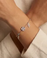 Pulsera de plata con cadena de eslabones, dije central de trébol de cuatro hojas con circonias pavé y dijes colgantes en forma de hoja.
