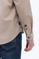 Camisa de pana de algodón con cuello clásico, cierre frontal de botones y mangas largas. Presenta un diseño de corte regular con textura suave y acabado mate.