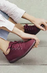 Zapatilla de diseño minimalista confeccionada en lana merino, con cordones al tono y suela de EVA. Presenta un estilo atemporal y versátil, ideal para uso diario.