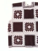 Chaleco sin mangas, confeccionado con cuadrados de cuero negro perforado combinados con cuadrados de crochet en hilo de algodón negro y blanco, con detalles centrales en rojo.