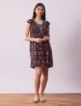 Camisón corto negro con estampado floral en tonos rosados y rojos. Escote en V con aplique de puntilla blanca y botones.