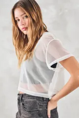 Remera corta de tul blanco, de corte holgado y mangas cortas.