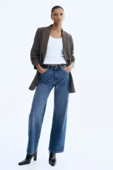 Blazer largo de botonadura sencilla con solapas de muesca, hombreras, pinzas en la cintura y bolsillos delanteros ribeteados. Presenta mangas tres cuartos con diseño remangado y forro interior.