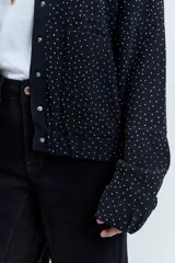 Bomber de punto color negro con apliques de strass brillantes, cuello redondo, cierre frontal con botones y mangas largas.