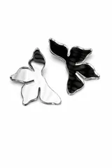 Aros colgantes de acrílico con diseño de silueta orgánica, uno en acabado espejado plateado y otro en acabado negro brillante con borde plateado.
